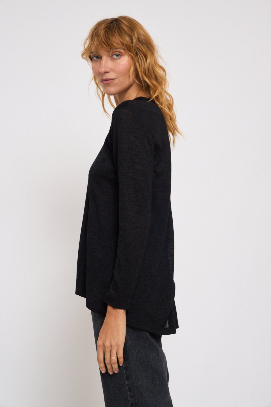 Woman wearing a black sweater against a white background