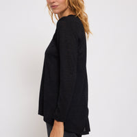 Woman wearing a black sweater against a white background