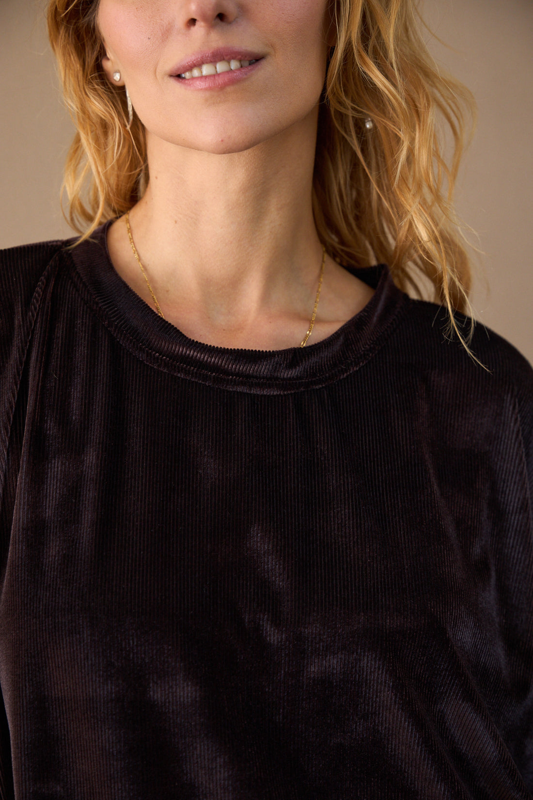 Close-up of a person wearing a black top with a neutral background